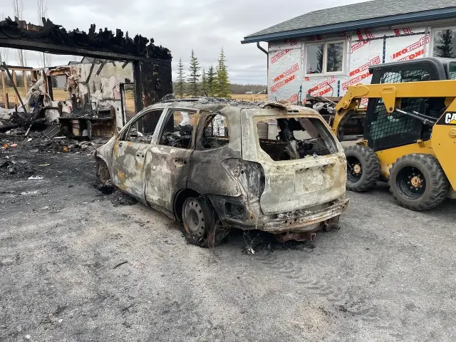 Fire-damaged vehicle and partially destroyed garage structure